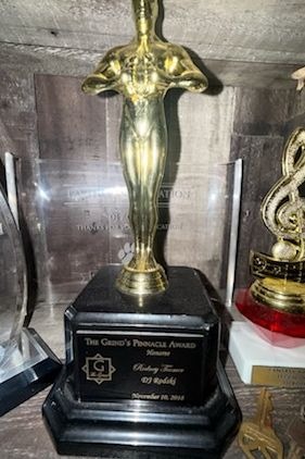 A gold figure trophy on a tiered black base with an engraved plaque
