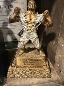 A gold statuette icon award on a square engraved base